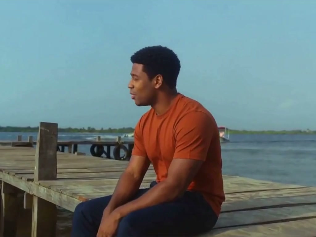 Fictional AI character wearing an orange top, seated on a wooden dock