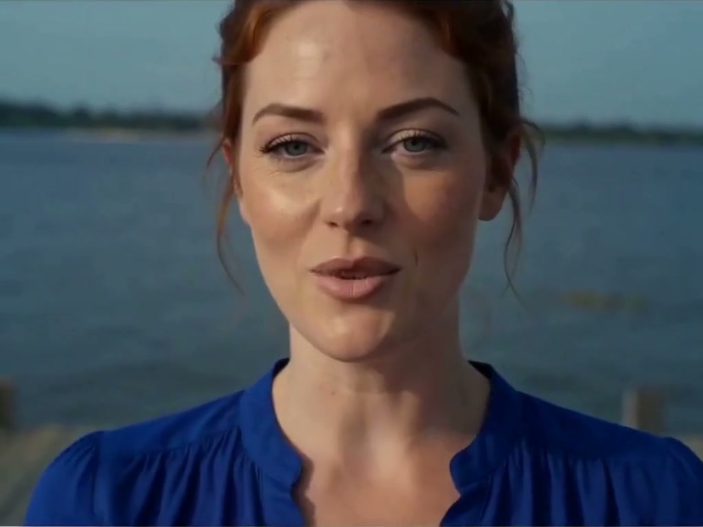 Fictional AI character with auburn hair and a blue top beside the water